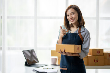 A woman is holding boxes and smiling