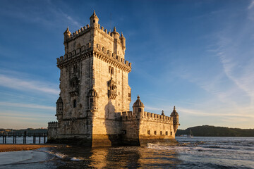 Obraz premium Belem Tower or Tower of St Vincent - famous tourist landmark of Lisboa and tourism attraction - on the bank of the Tagus River Tejo on sunset. Lisbon, Portugal