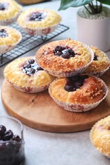 Blueberry streusel sweet bread with fresh berries and creamcheese on a wooden cutting board
