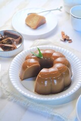 Traditional dessert brown sugar jelly pudding  called agar-agar gula merah on white plate
