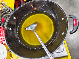 dirty cooking oil with piles of fried food residue in the pan.