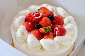 A Japanese-style strawberry shortcake with fresh cream, strawberries, raspberries and blueberries in a white cake box from Maki’s Patisserie in Sydney, Australia