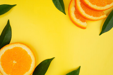 Summer fruit background concept, fresh orange slices and leaves with copy space