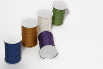 Spool of sewing thread, isolated on white background. Colored yarns used by factories in the clothing industry. Threads wound on the spool. Colored reels