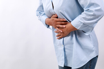 Close up photo of woman's hand holding stomach. Stomach ache concept