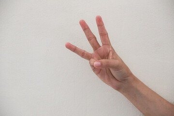 Close-up of hand showing number three gesture isolated on white background.