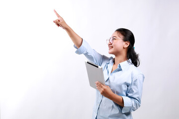 Attractive businesswoman holding a digital tablet while standing over white background pointing above