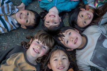 Group of happy children lying on the ground and looking at the camera