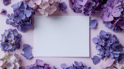 An empty white card framed by lush purple hydrangea flowers on a pastel pink background, perfect for invitations