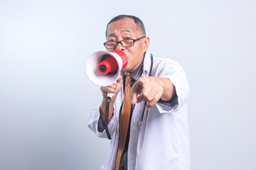 Potrait Of Senior Doctor Male Wear Glasses Shouting On Megaphone And Pointing At Camera Isolated On...