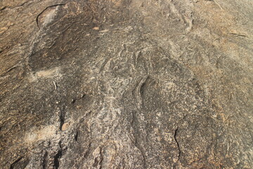 Details of sand stone texture, closeup shot of rock surface with vignette at cover and bright spot at centre, idea for background or backdrop.