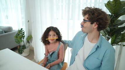 Funny caucasian dad and american kid doing funny face while put pencil between lip and nose. Cute...