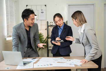 Group of Asian business men and women sitting and looking at documents at the office.