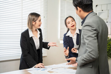 Group of Asian business men and women sitting and looking at documents at the office.
