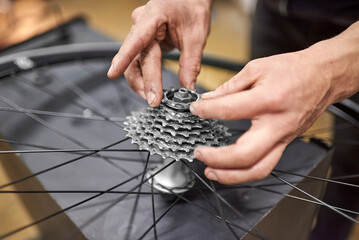 Maintenance of a bicycle: hands of an unrecognizable person assembling the sprocket set of a bike...