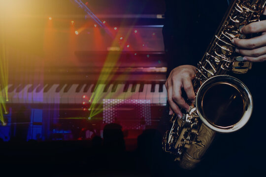 Double exposure of Young Saxophone Player hands  playing alto sax musical instrument over the piano with concrt light background,   can be used for music