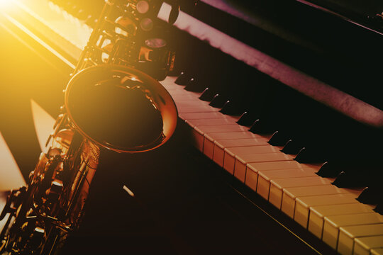 close up of saxophone and piano keys with window light, copy space, music background

