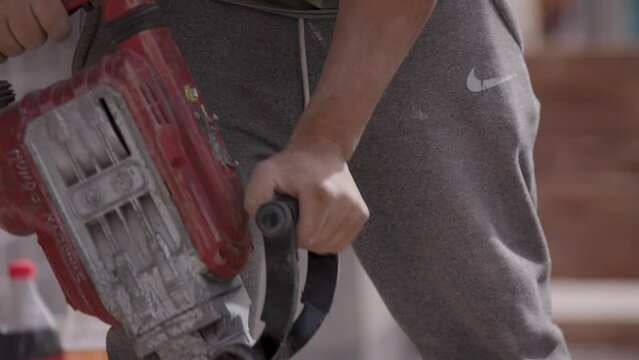 Demoledor o taladro el&eacute;ctrico. Trabajador agujereando el piso con taladro el&eacute;ctrico. Trabajador industrial o de construcci&oacute;n trabajando.