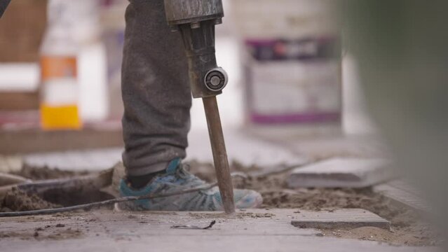 Demoledor o taladro el&eacute;ctrico. Trabajador agujereando el piso con taladro el&eacute;ctrico. Trabajador industrial o de construcci&oacute;n trabajando.