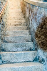 Rustic stone steps in a narrow passage illuminated by sunlight, with textured walls, in Slovenia
