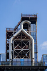 An industrial facility is built on the roof of a modern building with glass curtain walls