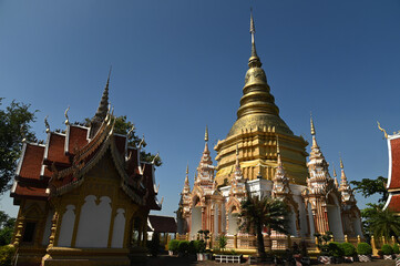 Fototapeta premium Large golden outdoor pagoda at Wat Phra Phutthabat Tak Pha It is believed to be the footprint of the Buddha who came to rest in the area where the robes were dried. Located at Lampun in Thailand.