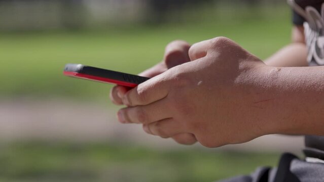 Mano usando tel&eacute;fono celular al aire libre