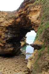Natural rock formation with an archway leading to a view of the sea at The Grotto on the Great Ocean Road in Victoria, Australia