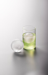 유리잔안에 탄산음료와 둥근 얼음.