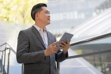 Fototapeta premium Professional businessman using tablet outdoors