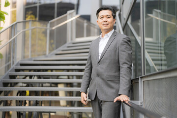 Confident businessman standing outdoors by staircase
