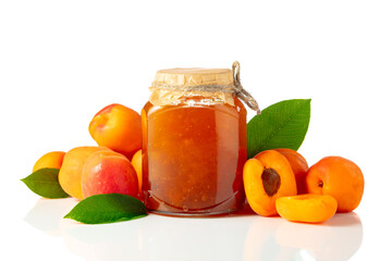Apricot jam in glass jar and fresh fruits isolated on white.