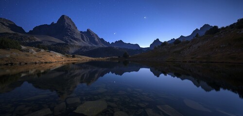 Fototapeta na wymiar A serene mountain lake at night, reflecting the clear, star-filled sky and the shadows of surrounding peaks. 32k, full ultra HD, high resolution