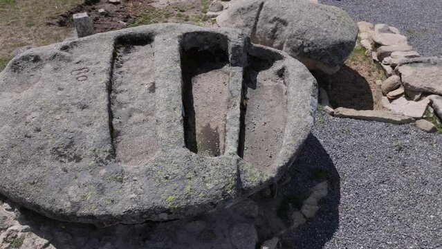 lateral flight with drone where we see 3 anthropomorphic tombs from the Visigoth period excavated in a rock, there is also a number 80 engraved, there is dark gravel from the archaeological zone