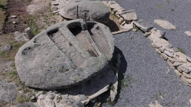 orbital and ascending flight with drone where we see 3 anthropomorphic tombs from the Visigoth era excavated in a rock there is dark gravel from the archaeological zone there are remains of walls