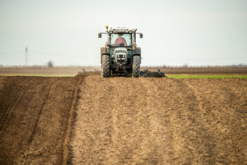 Powerful tractor with plow in action, turning the rich soil for new crops