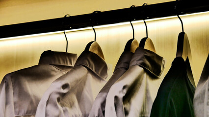 Close-up of elegant men's shirts hanging on the hangers in a wardrobe