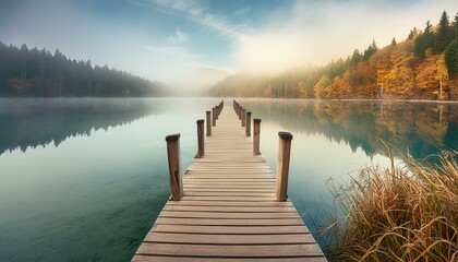 Serenity in the Mist: Wooden Jetty Bridge at a Foggy Autumn Lake"