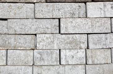 A closeup of a pile of stacked gray sand-lime bricks for building a house. Gray sand-lime brick