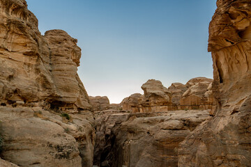 Fototapeta premium View of the narrow Siq canyon pathway leading to Petra, Jordan, with towering sandstone cliffs.