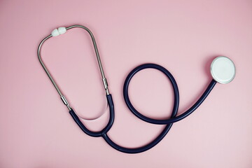 Stethoscope top view on pink background