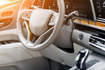 Modern car interior view with dashboard, multifunction steering wheel, speedometer.