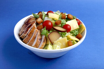 Salmon Salad with spinach, cherry tomatoes, corn salad, baby spinach, fresh mint and basil. Home made food. Concept for a tasty and healthy meal. Blue background top view. Copy space.