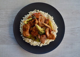 Moon shadow pork marinated in a black bean and honey sauce with vegetables and served on a bed of brown jasmine rice.