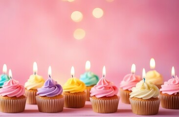 birthday cupcakes with a candles on a pink background with copy spase