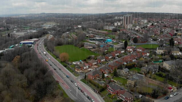Aerial drone Footage above a typical housing estate in the UK on a rainy cold day with rows of houses and roads with traffic taken in Kirkstall in Leeds West Yorkshire UK in the rain