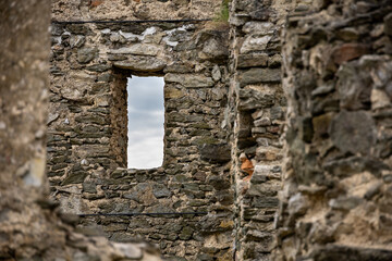 Old stone walls and view through window to cloudy sky
