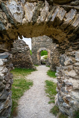 View through archway in wall of ruins of medieval castle