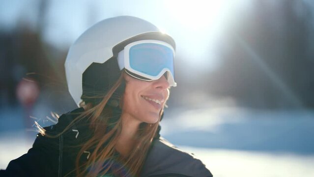 Close-up portrait of woman snowboarder skyer in ski helmet and glasses in mountains landscape. Girl wearing in ski clothes in winter resort. Enjoy healthy sport active rest, snowboarding lifestyle.