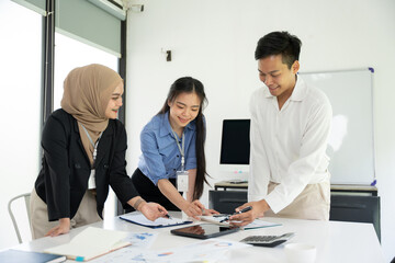 Fototapeta premium Group of Asian business people planning a project, discussing work documents.